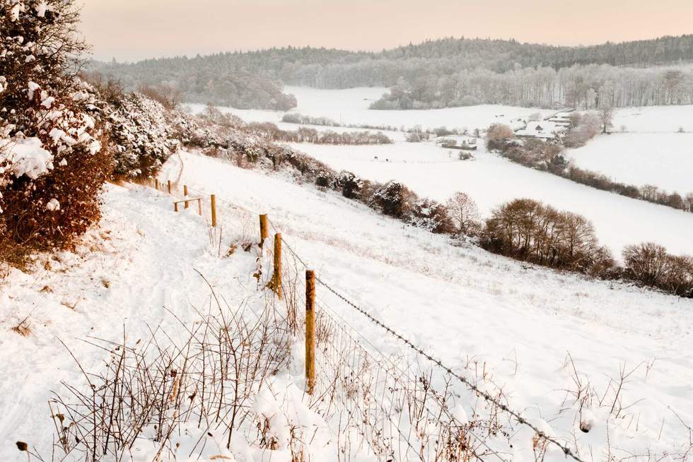 A view over some snow covered fields at dusk.  Taken on Pewley Down in Guildford, Surrey on a snowy December evening.