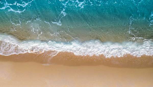 Beach Sand Sea Shore with Blue wave and white foamy summer background, Aerial beach top view overhead seaside.