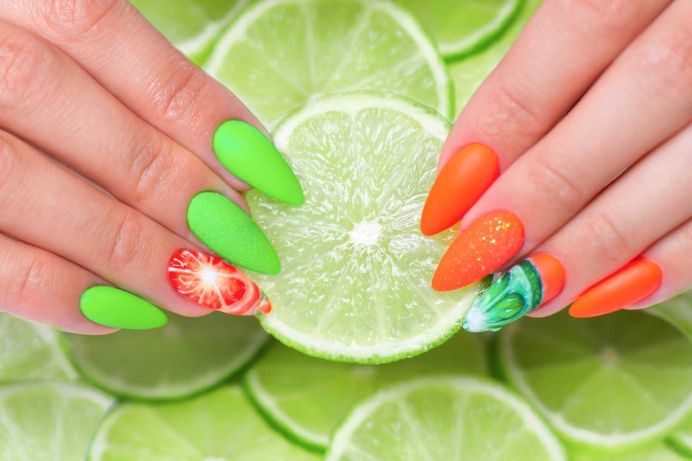 Beautiful female hands with summer manicure nails, orange and green gel polish