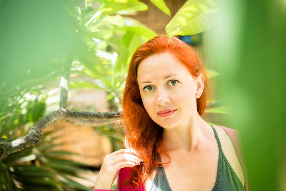 Beautiful red girl in lush tropical forest