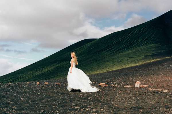 beautiful young bride in white wedding dress walking at amazing icelandic nature