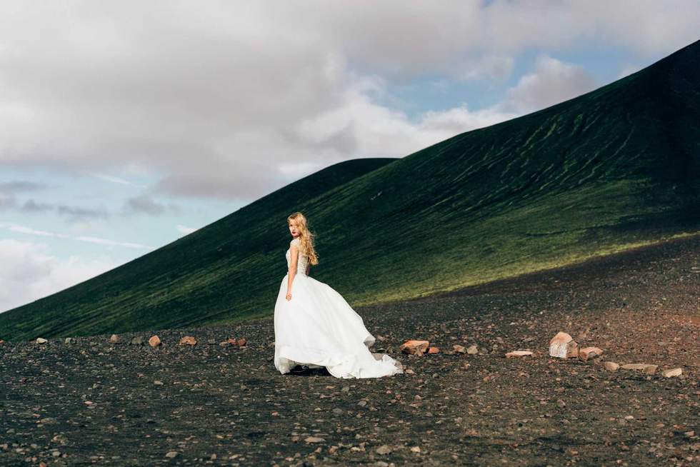 beautiful young bride in white wedding dress walking at amazing icelandic nature