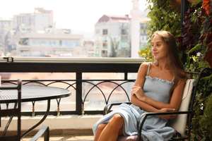 Beautiful young woman on balcony. Space for text