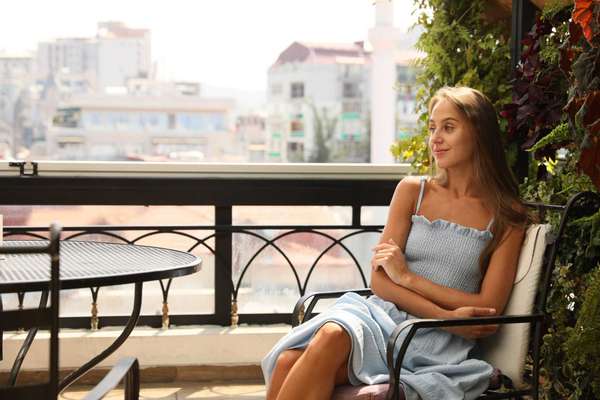 Beautiful young woman on balcony. Space for text