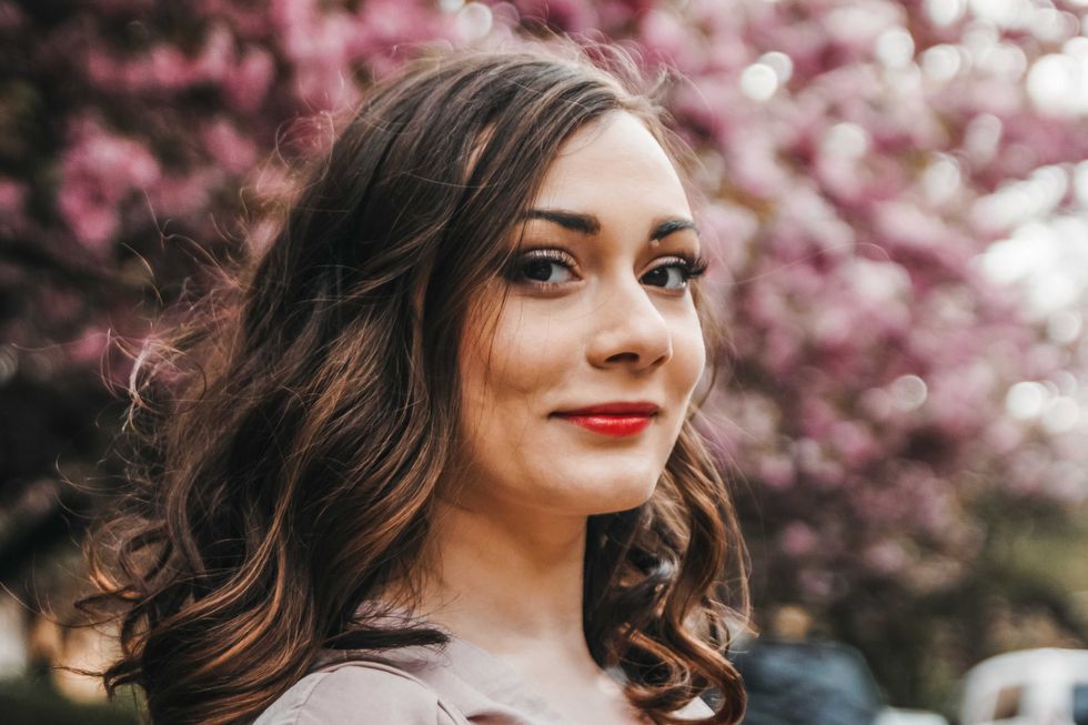 Close up portait of a happy female with sakura in the background