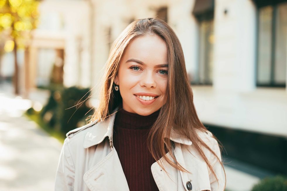 Close up portrait of beautiful smiling young woman outdoor during autumn.
