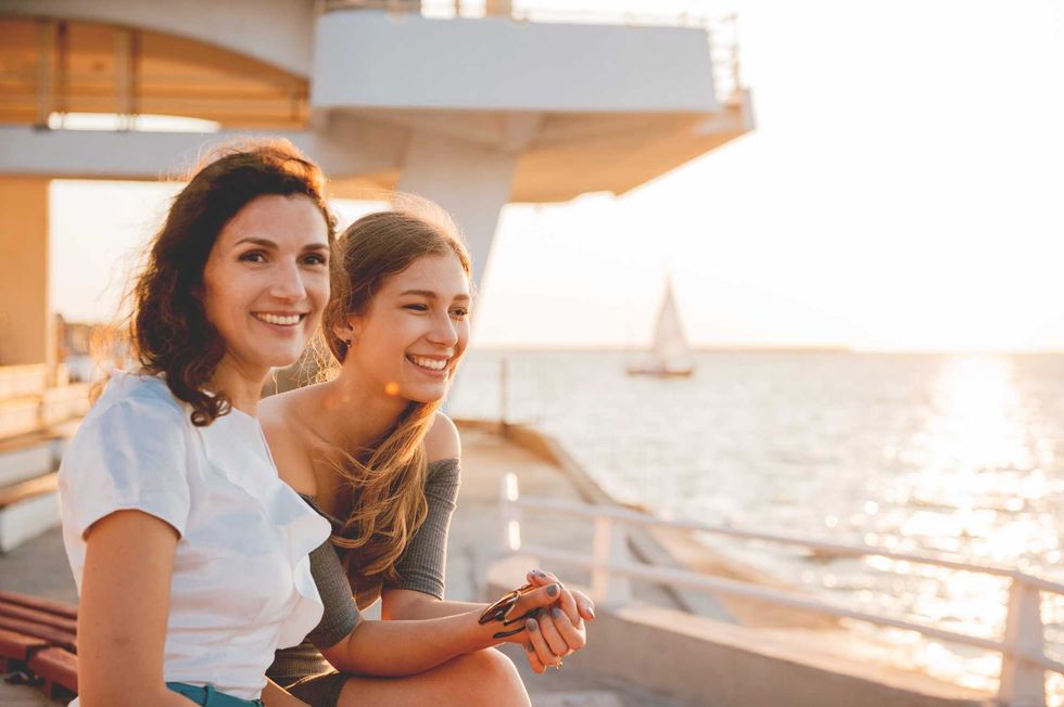 Close-up portrait of happy mother with a teenage daughter. Sunset light.