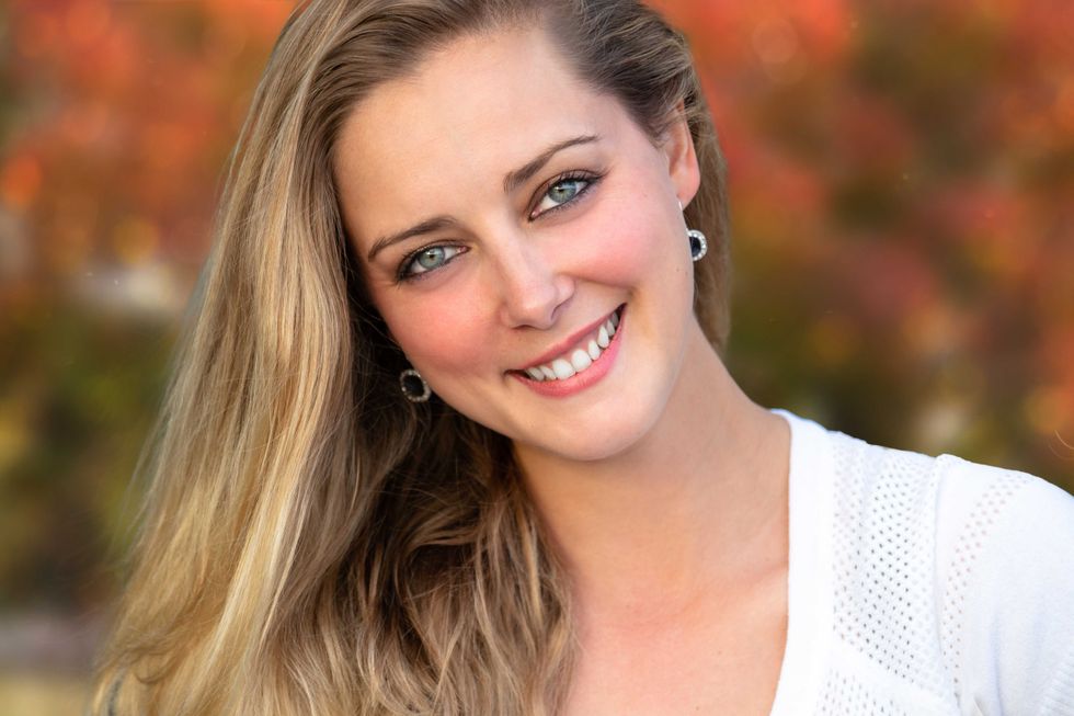 Headshot of a beautiful blonde woman outdoors, closeup smiling portrait, happy and cheerful