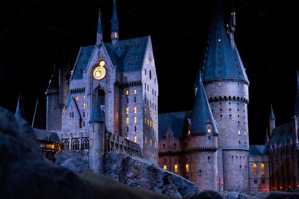 JAPAN - Nov 13, 2023: Closeup night view of Hogwarts Castle's clock tower illuminated beautifully highlighting its magical architecture at Warner Bros. Studio Tour Tokyo, The Making of Harry Potter