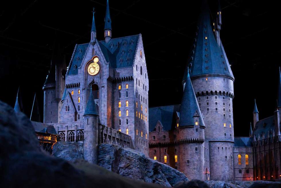 JAPAN - Nov 13, 2023: Closeup night view of Hogwarts Castle's clock tower illuminated beautifully highlighting its magical architecture at Warner Bros. Studio Tour Tokyo, The Making of Harry Potter