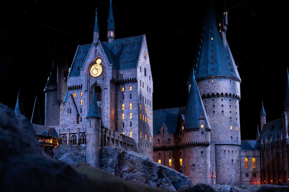JAPAN - Nov 13, 2023: Closeup night view of Hogwarts Castle's clock tower illuminated beautifully highlighting its magical architecture at Warner Bros. Studio Tour Tokyo, The Making of Harry Potter