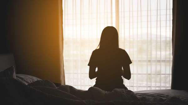 Kenstocker - stock.adobe.com - illustrative purposes only, not the actual person - pictured above is a girl sitting on a bed