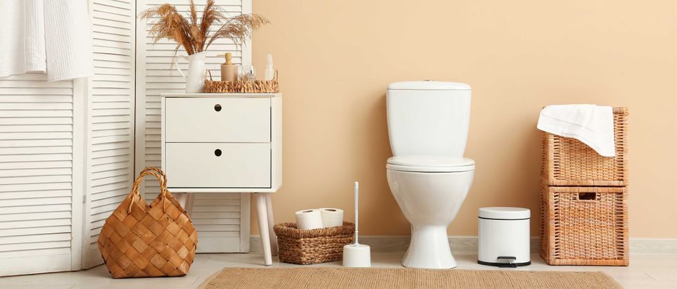 Modern bathroom interior design with white toilet, wooden furniture, and natural decor elements