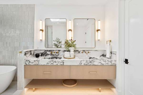 Modern bathroom with marble countertop and dual mirrors.