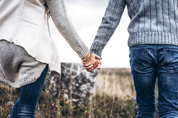 Photo of romatic couple hands, walking outdoor and spending time together