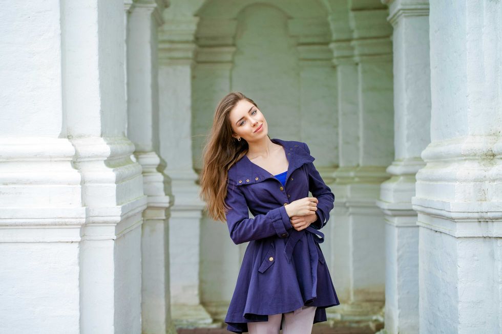 Portrait of a beautiful young brunette woman in dark blue coat