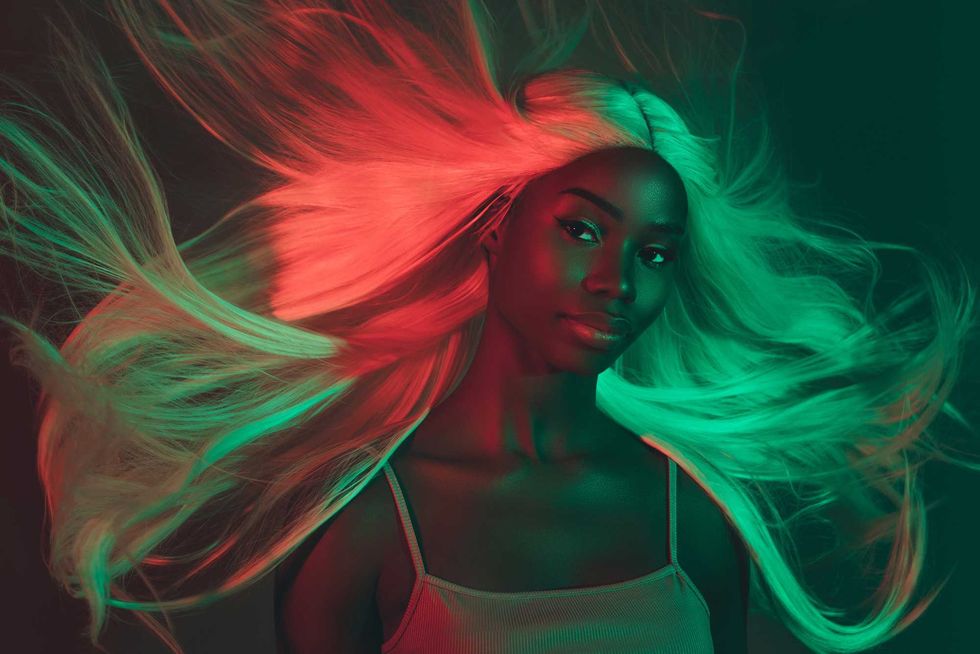 Portrait of adorable gentle lady demonstrate shine glance strong hair flying after spa procedure on dark background.