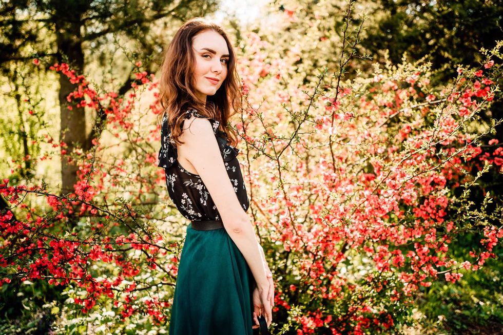 portrait of beautiful young girl in dress in flowering spring garden, female portrait outdoors