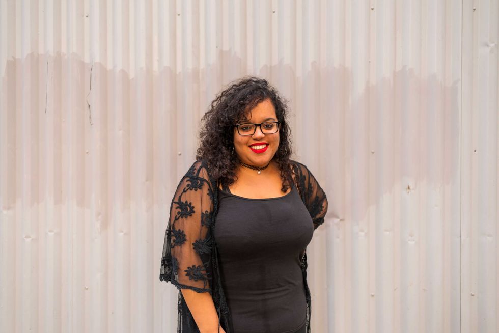 Portrait of Moroccan woman with black glasses posing in a gray sheets
