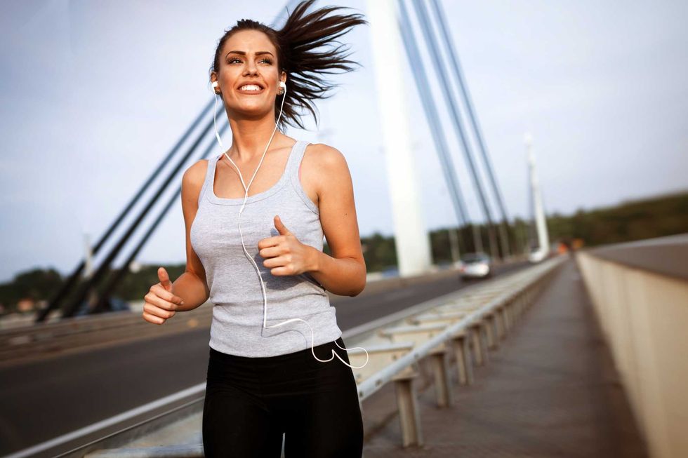 Pretty female jogger running and staying active