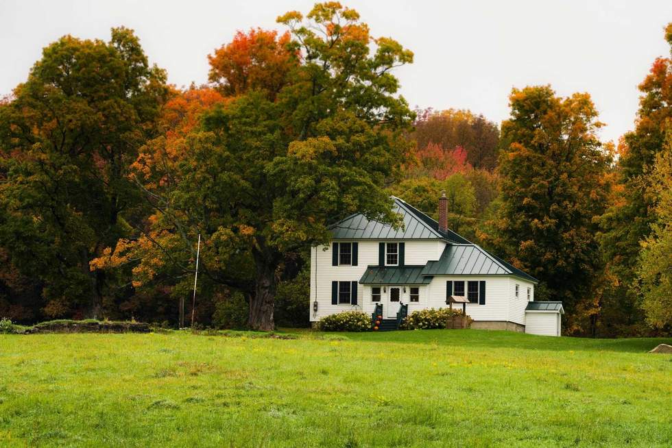 Rustic farm scene in rural vermont during autumn with fall colors changing and a bountiful harvest and a traditional American scene depicting home for the holidays