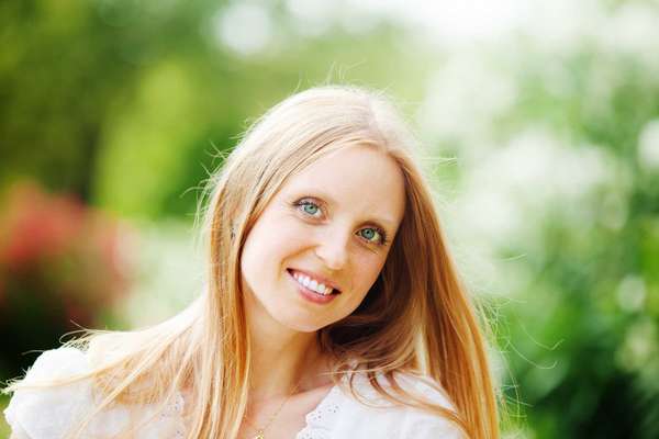 Smiling beautiful blonde middle-aged woman against nature background