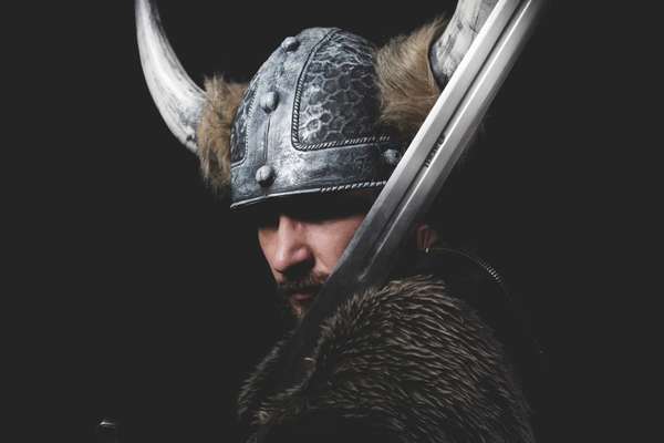 Viking warrior with iron sword and helmet with horns