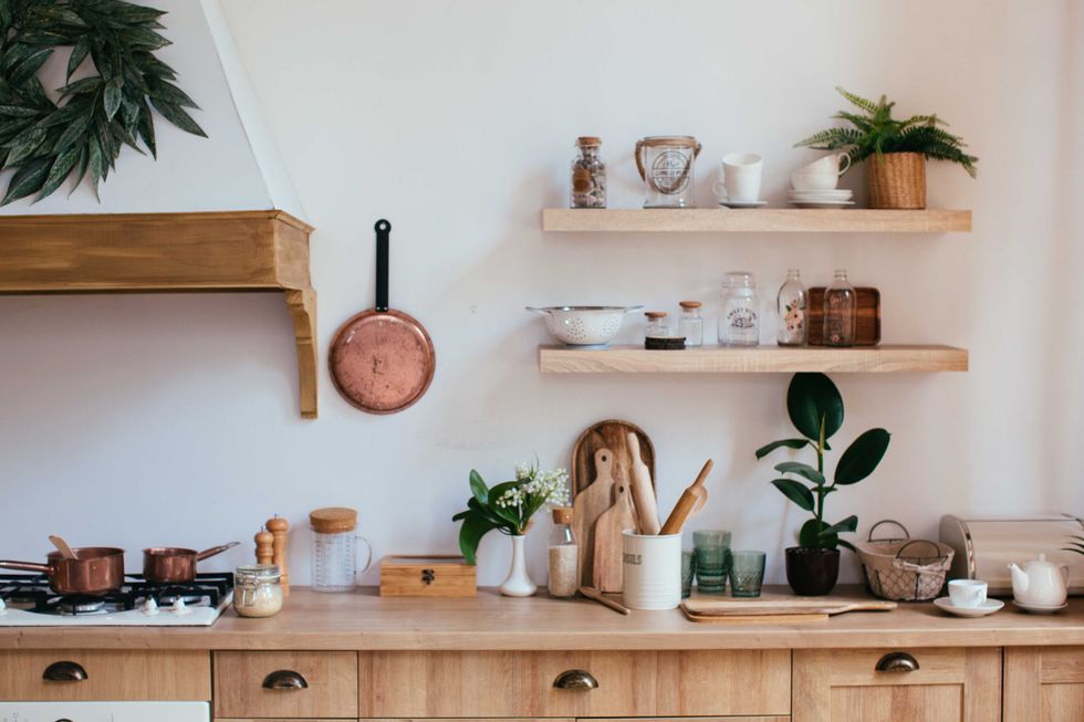 wooden rustic kitchen table. minimalistic interior, utencils on the table, jars on shelf