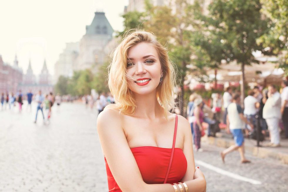 young beautiful girl in a white skirt and a red top. walking in the park and city