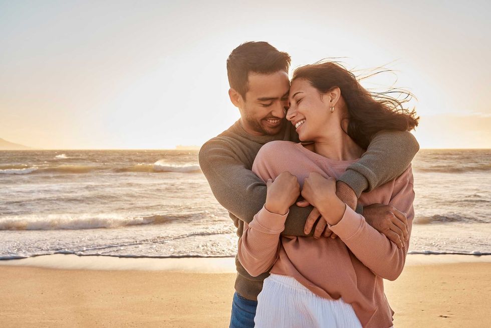 Young diverse biracial couple having fun at the beach together.
