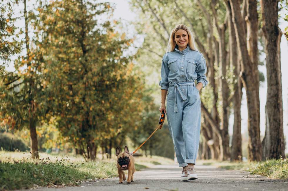 Young woman with her pet french bulldog in park